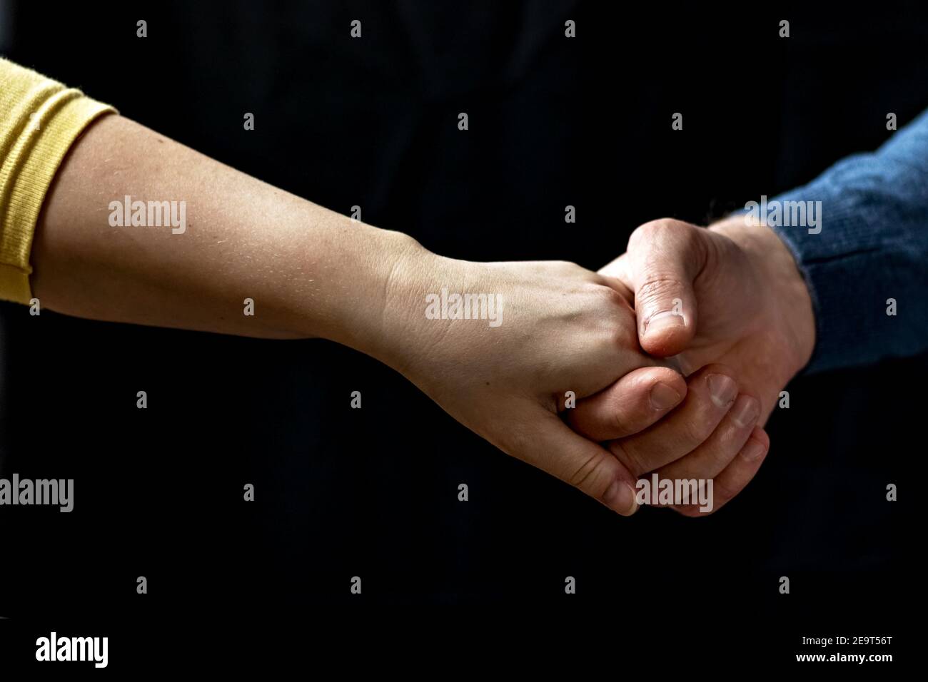 Giovane coppia che tiene le mani mostrando amore e cura, marito e moglie sono teneramente vicini insieme, mostrando sostegno e comprensione. Foto Stock