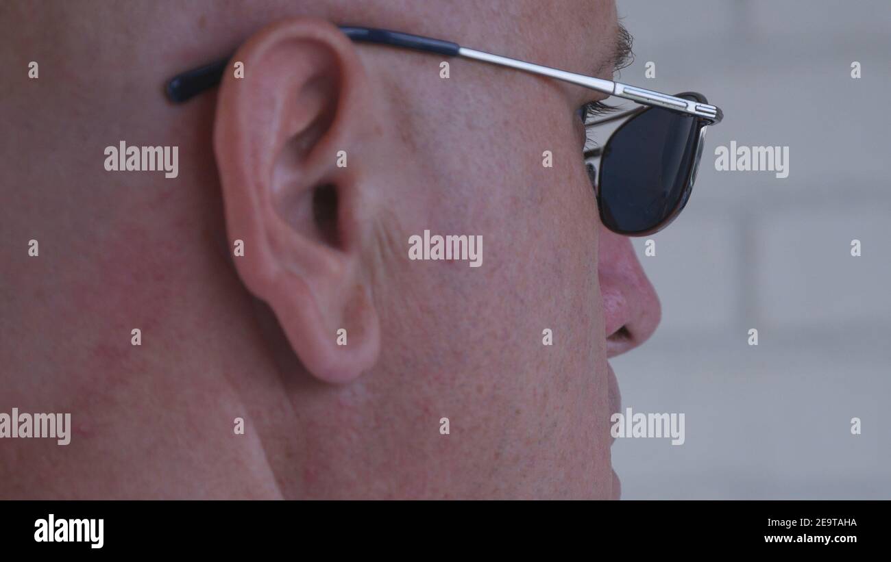 Immagine Bodyguard che indossa occhiali da sole neri facendo un lavoro di sicurezza. Foto Stock