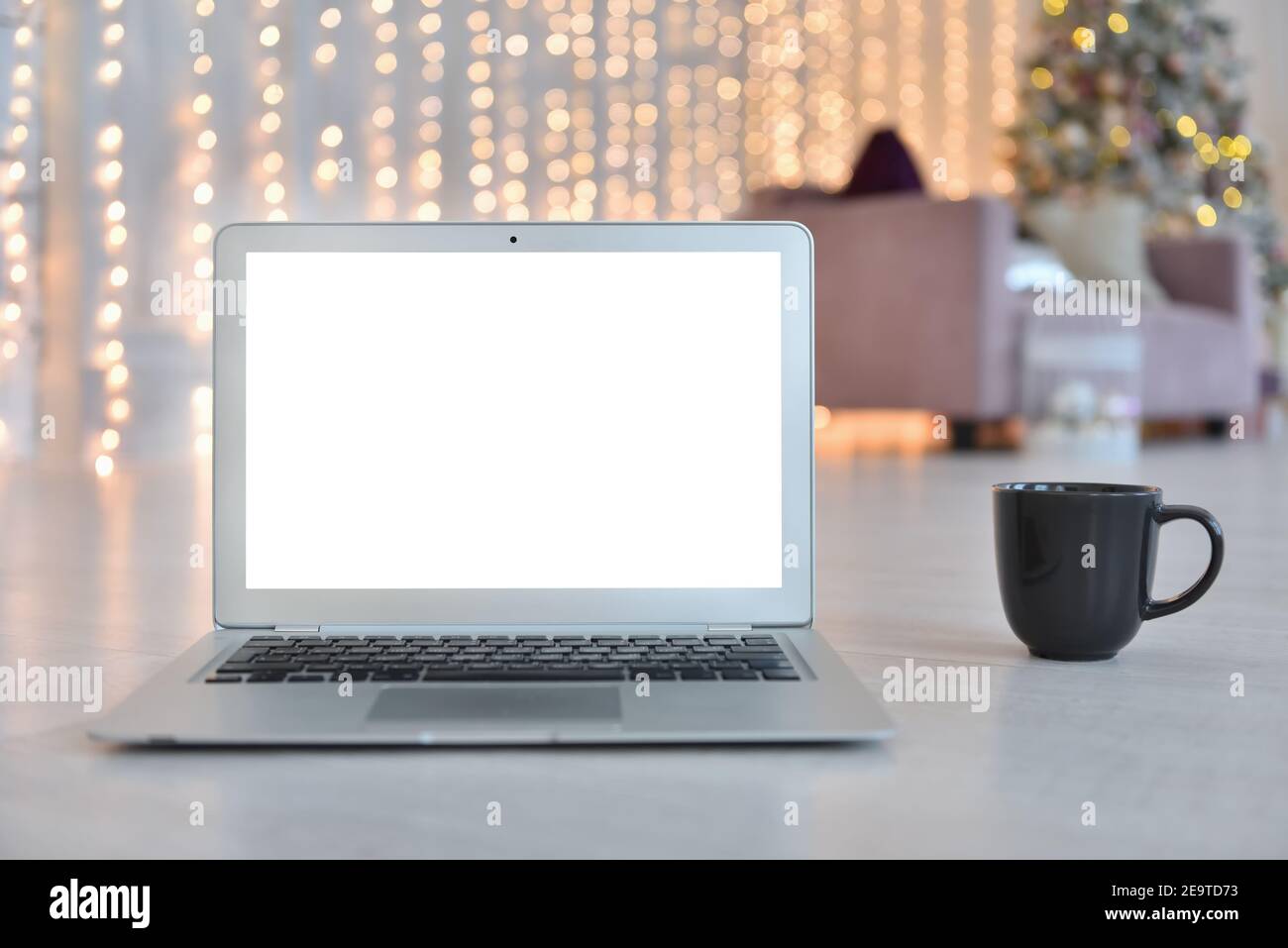 Mockup del portatile con schermo bianco vuoto sullo sfondo di Natale interno Foto Stock