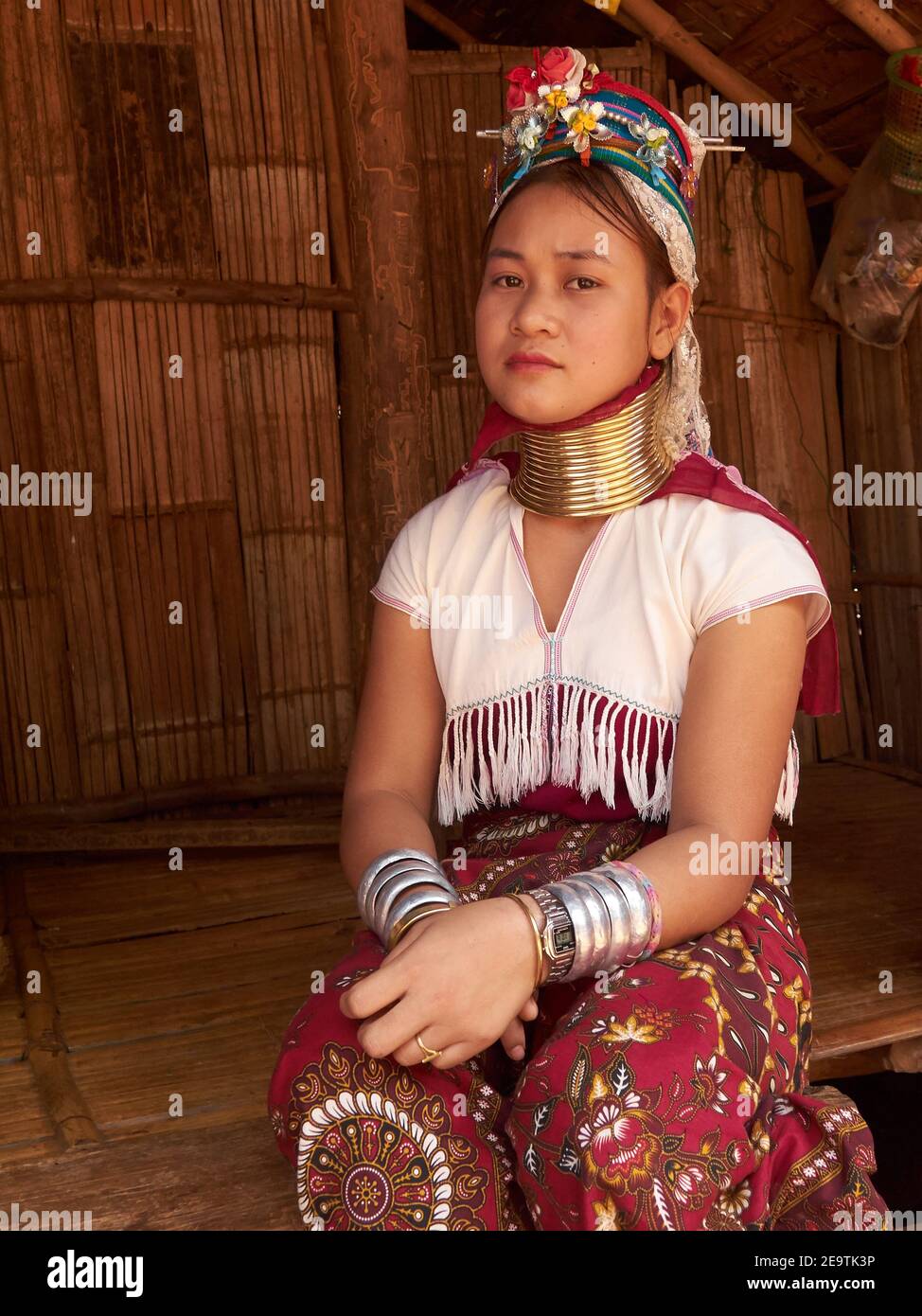 Pose di una donna tribale di Karen Hill con braccialetti di gioielli in entrambe le mani e una collana unica intorno al suo lungo collo Foto Stock