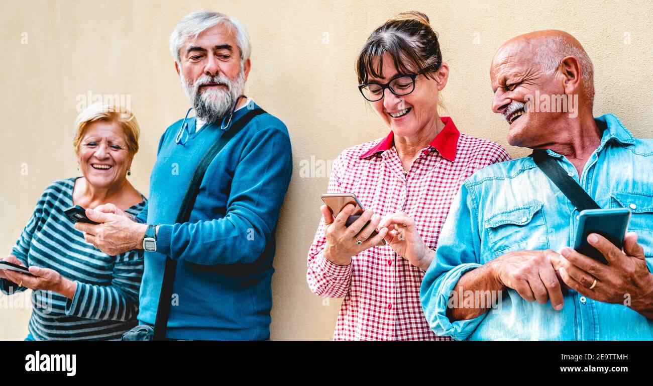 Felici gli amici senior che si divertono con i moderni smartphone - Persone in pensione che condividono contenuti online con il cellulare - positivo stile di vita anziano Foto Stock