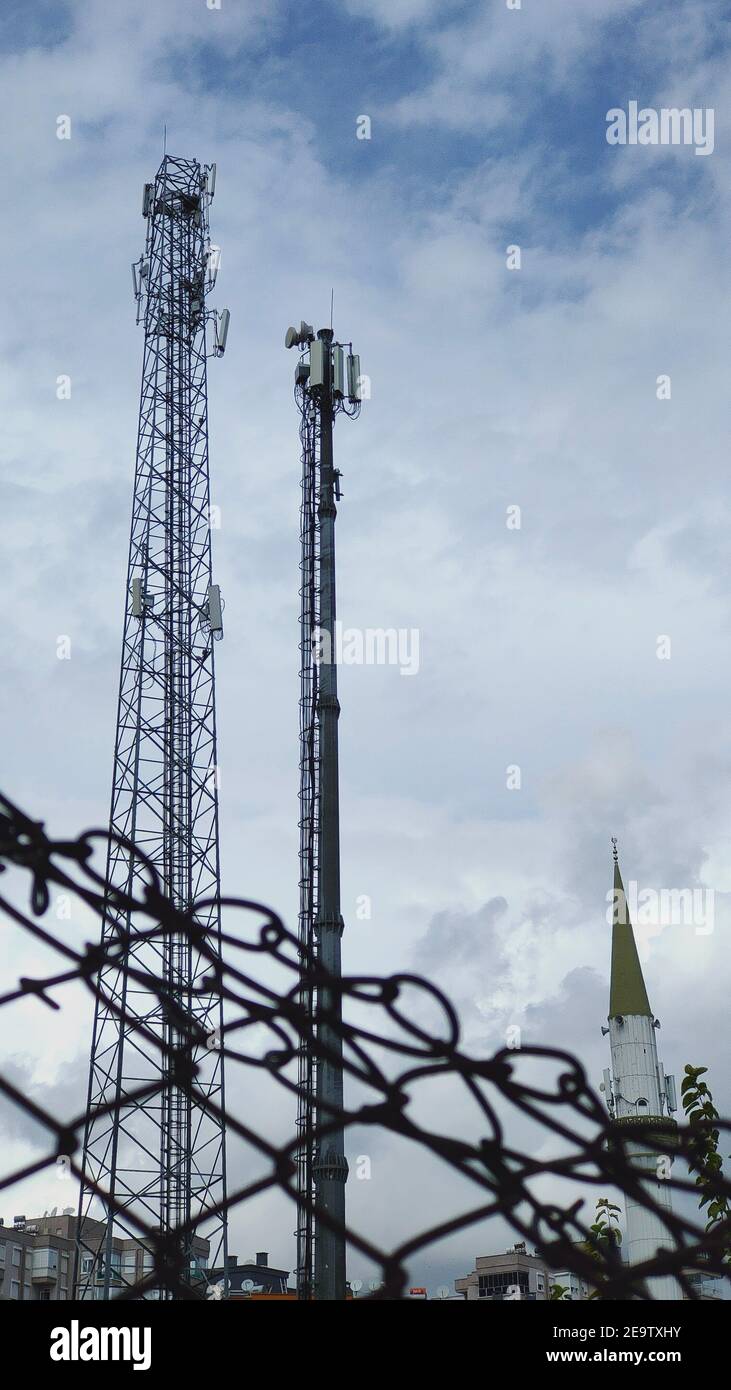 Minareti moschee e torri di rete cellulare con recinzione. Concetto di libertà di parola Foto Stock