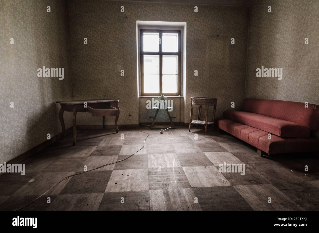 camera vecchia abbandonata con un divano rosso Foto Stock