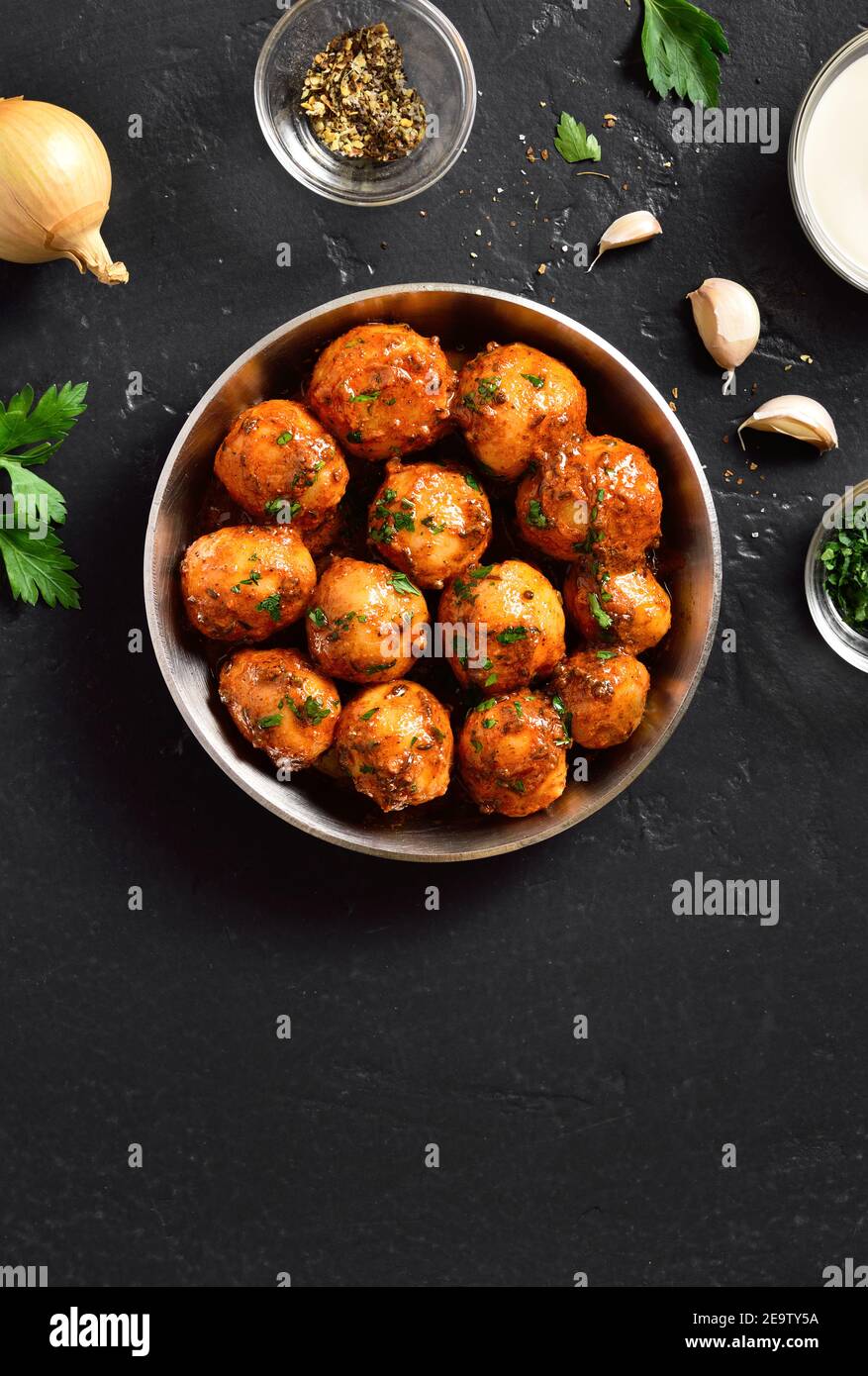 Patate Bombay. Pan patate fritte piccolo bambino con i semi di jeera e coriandolo in ciotola su sfondo scuro con spazio libero di testo. Popolare piatto indiano. Foto Stock