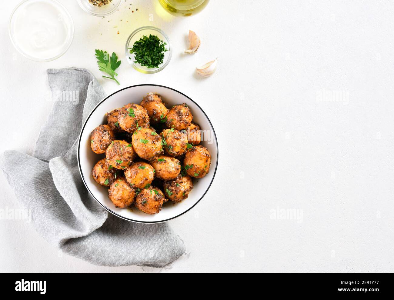 Patate Bombay. Pan patate fritte piccolo bambino con i semi di jeera e coriandolo in ciotola su sfondo chiaro con spazio libero di testo. Popolare piatto indiano. Foto Stock