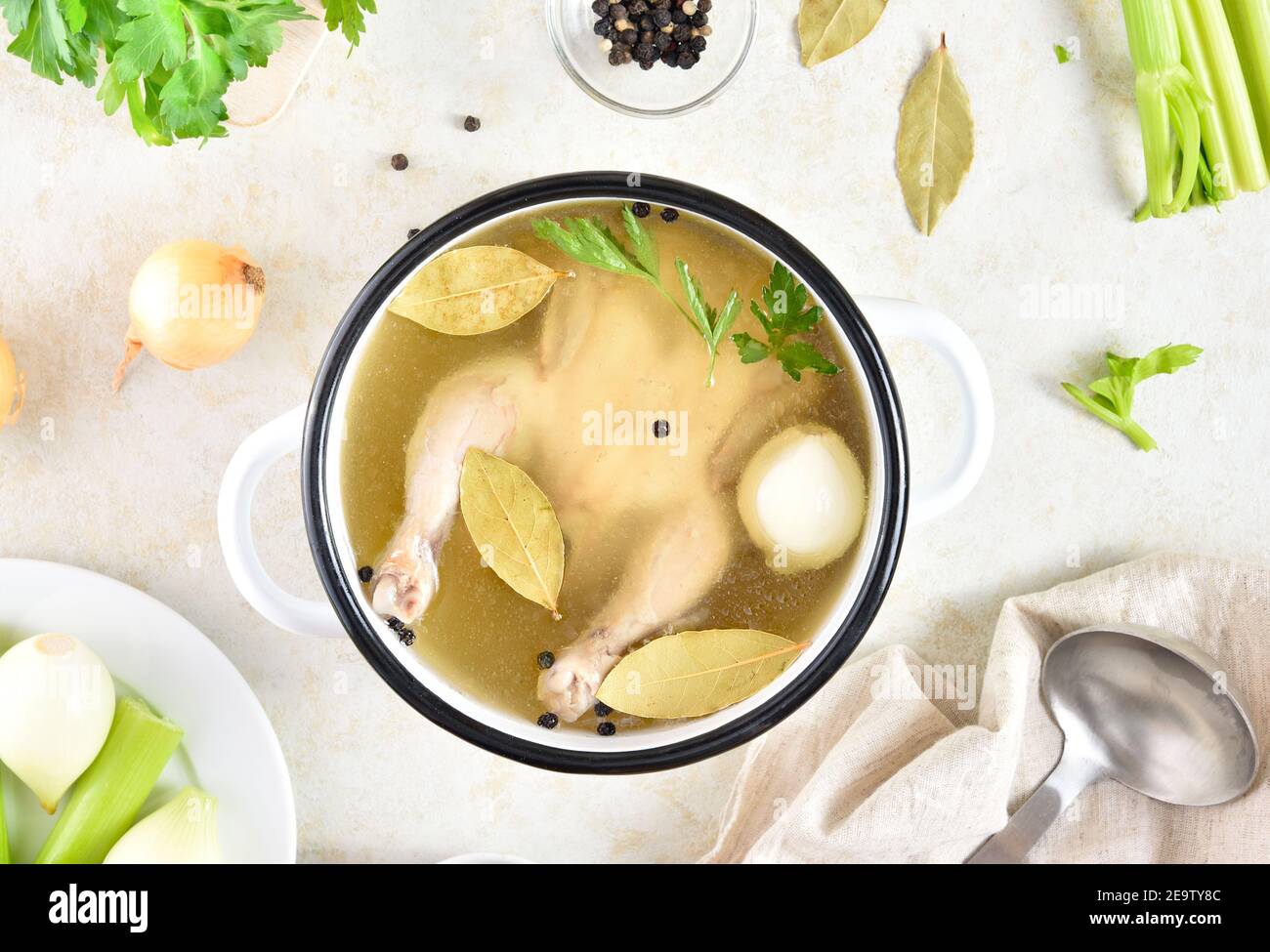 Brodo di pollo con verdure e spezie su fondo di pietra chiaro. Piatto di dieta sana per cena. Vista dall'alto, disposizione piatta Foto Stock