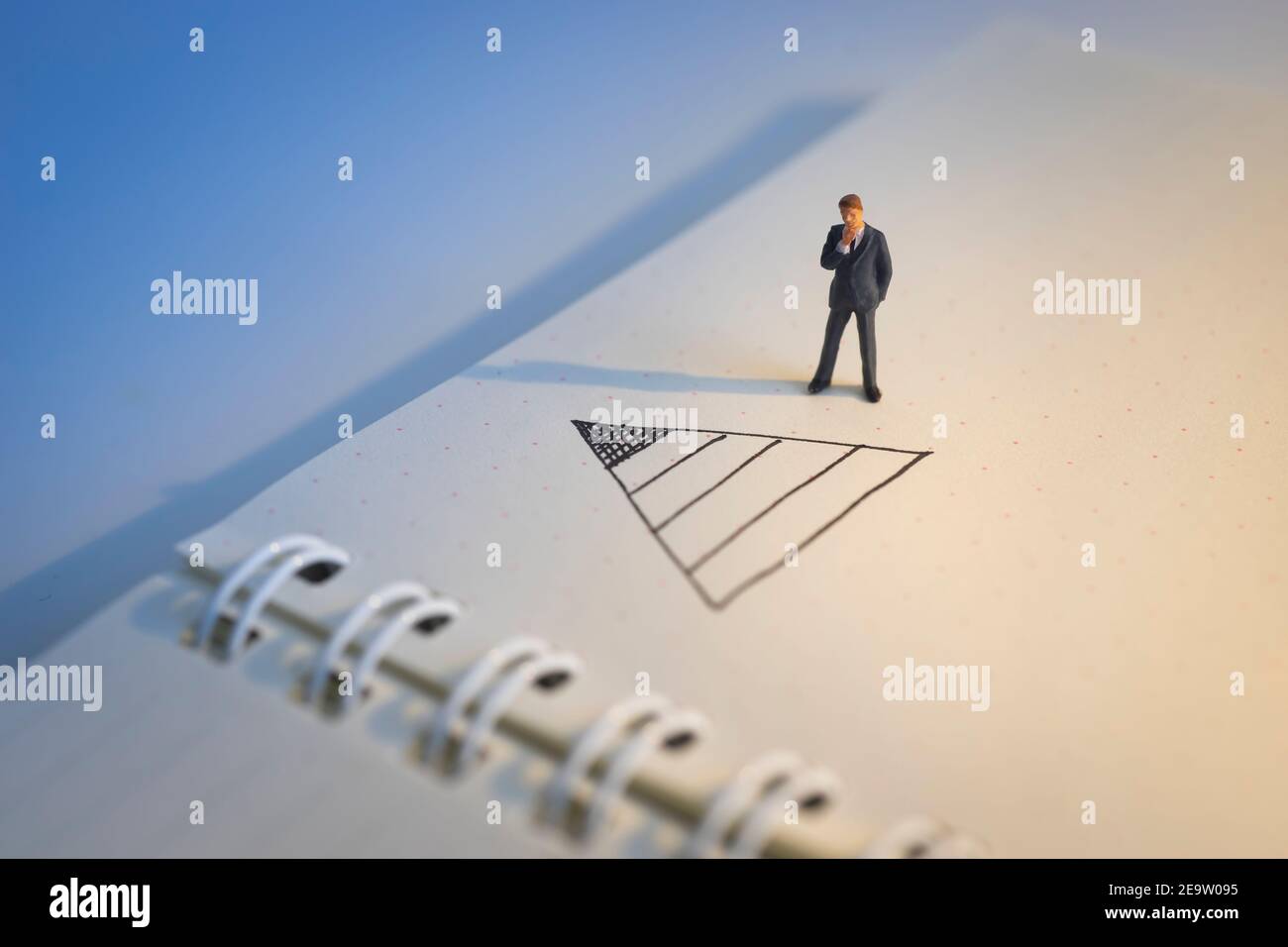 Concetto di decisione aziendale. Uomo d'affari che pensa con la cima del doodle del grafico della piramide Foto Stock