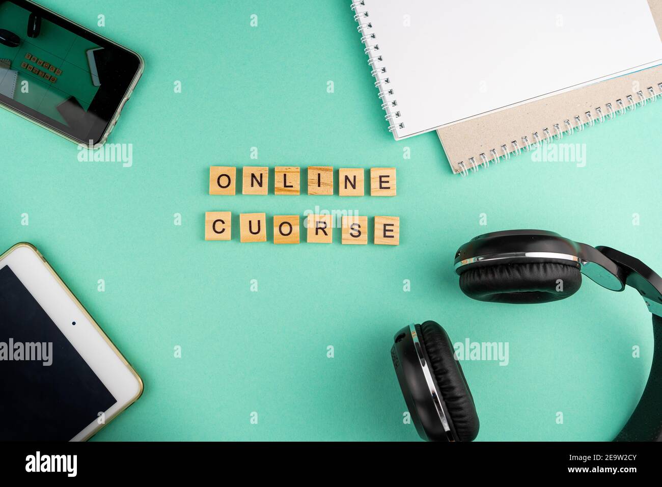 Corso online. La frase è scritta in lettere di legno. Vista dall'alto. Motivazione. Copy space.Tablet, cancelleria per cuffie. Apprendimento a distanza. Scheda Foto Stock