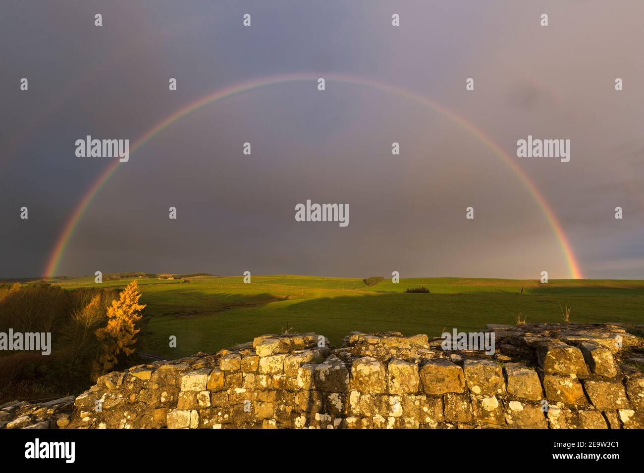 Un arcobaleno illumina il cielo oltre il Muro di Adriano a Cawfield, Northumberland, Regno Unito Foto Stock