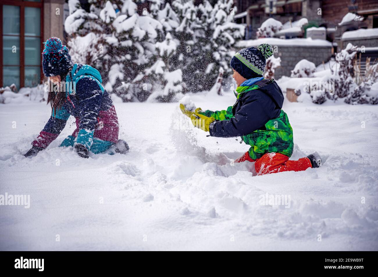 Bambini che giocano con la neve. Due bambini asiatici in abbigliamento da sci che gettano la neve in inverno. Felice infanzia e insieme. Zermatt, Svizzera. Foto Stock