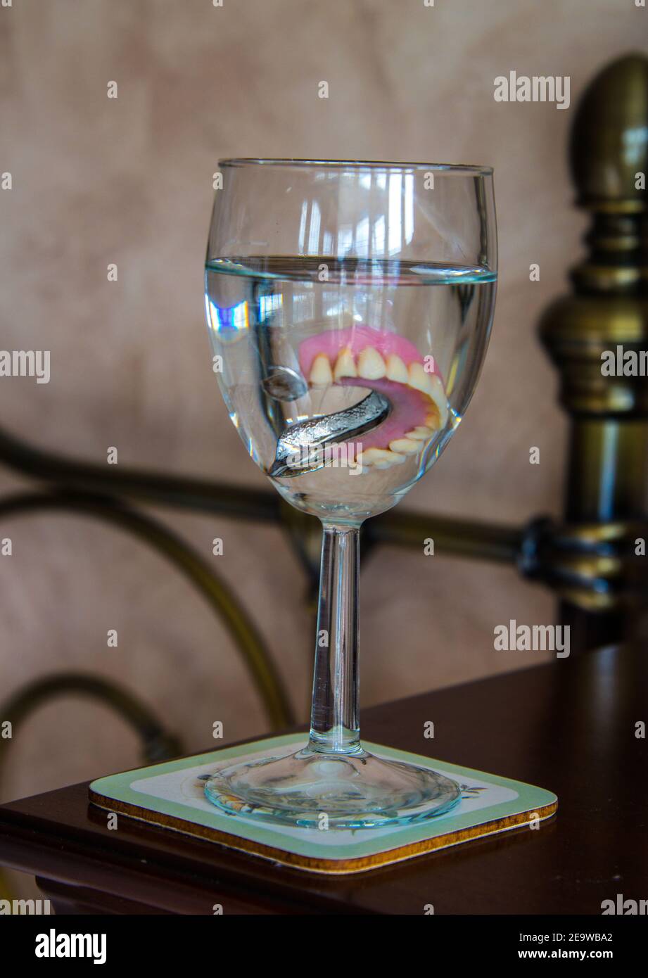 Dentures in un bicchiere di vino. Foto Stock