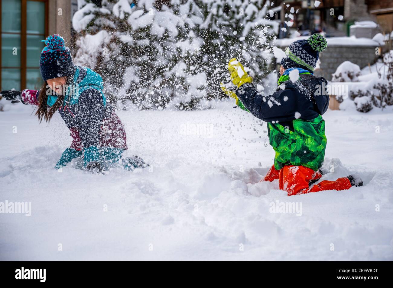 Bambini che giocano con la neve. Due bambini asiatici in abbigliamento da sci che gettano la neve in inverno. Felice infanzia e insieme. Zermatt, Svizzera. Foto Stock