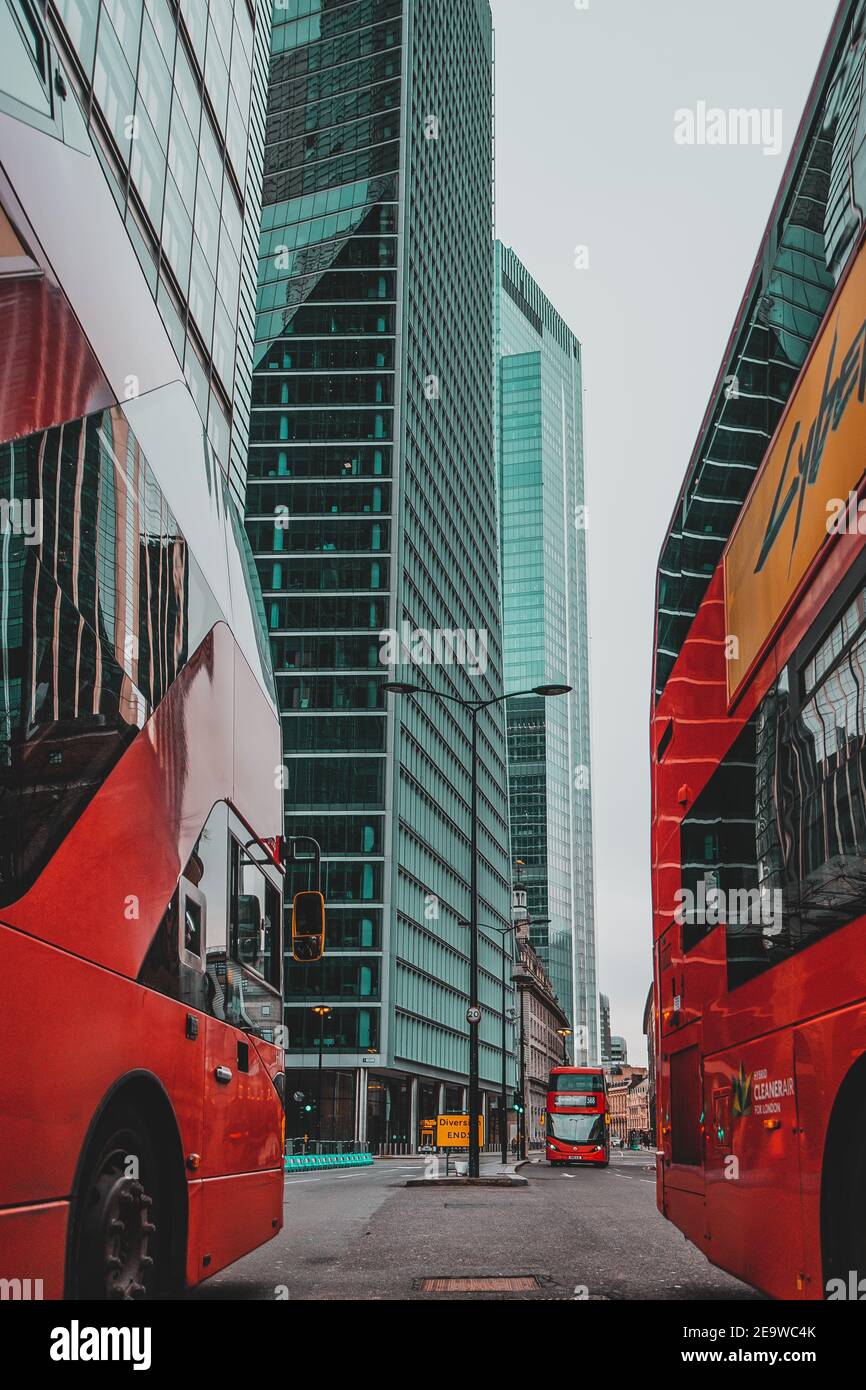 Londra UK Gennaio 2021 immagine verticale di un moderno autobus a due piani rosso che guida sulle strade vuote di Londra in blocco, alto e massiccio grattacielo Foto Stock