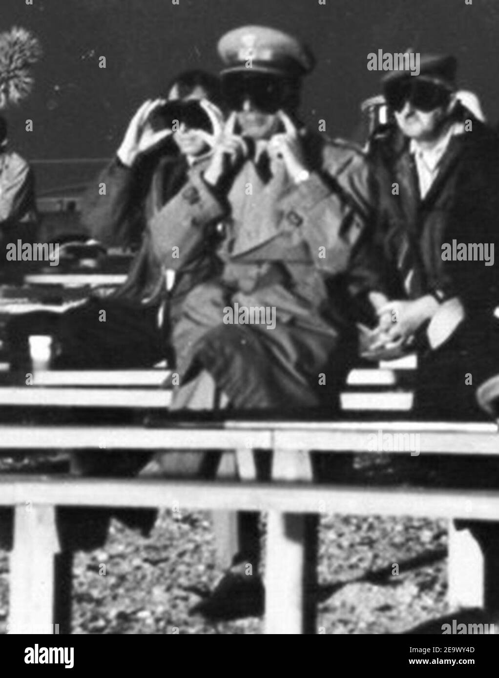 Ufficiale della NATO che tiene le orecchie in preparazione per l'esplosione nucleare (test) il 28 maggio 1957 presso il Nevada Test Site, da- spettatori nucleari (corto). Foto Stock