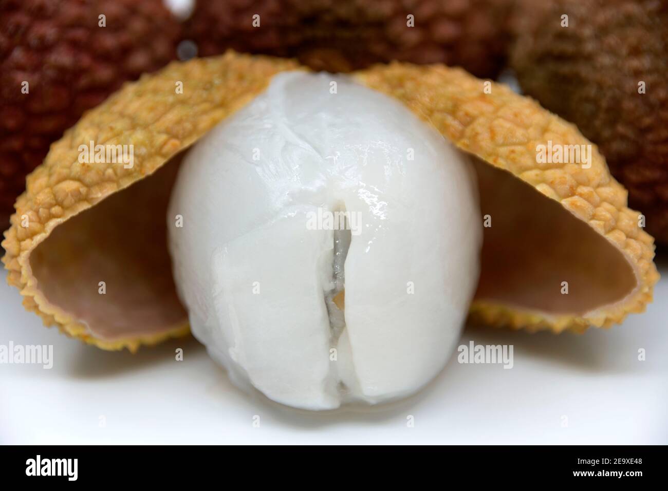 Lychee - tradotto da cinese 'prugne cinese'. Un piccolo frutto dolce e agrodolce, coperto da una crosta dura con un osso all'interno. Cresce sul tropico sempreverde Foto Stock