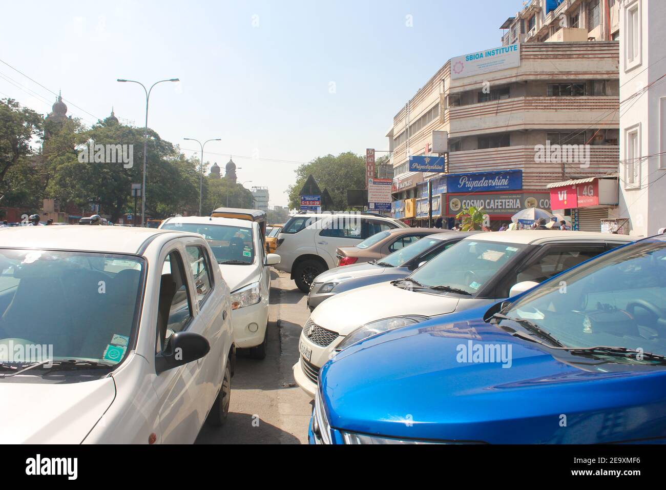 Traffico pesante nel centro città dell'India. Vari negozi, caffè, ristoranti. Foto Stock
