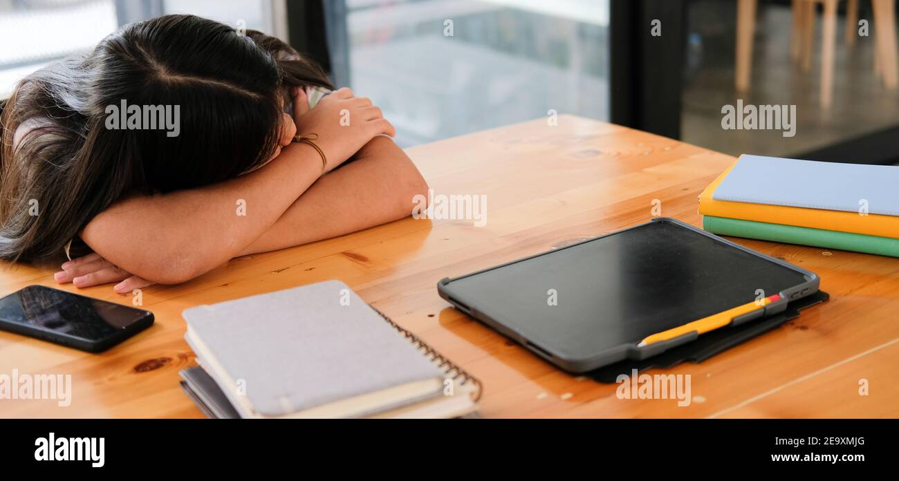 stanco esausto studentessa asiatica che dorme dopo aver studiato esame duro nella libreria Foto Stock