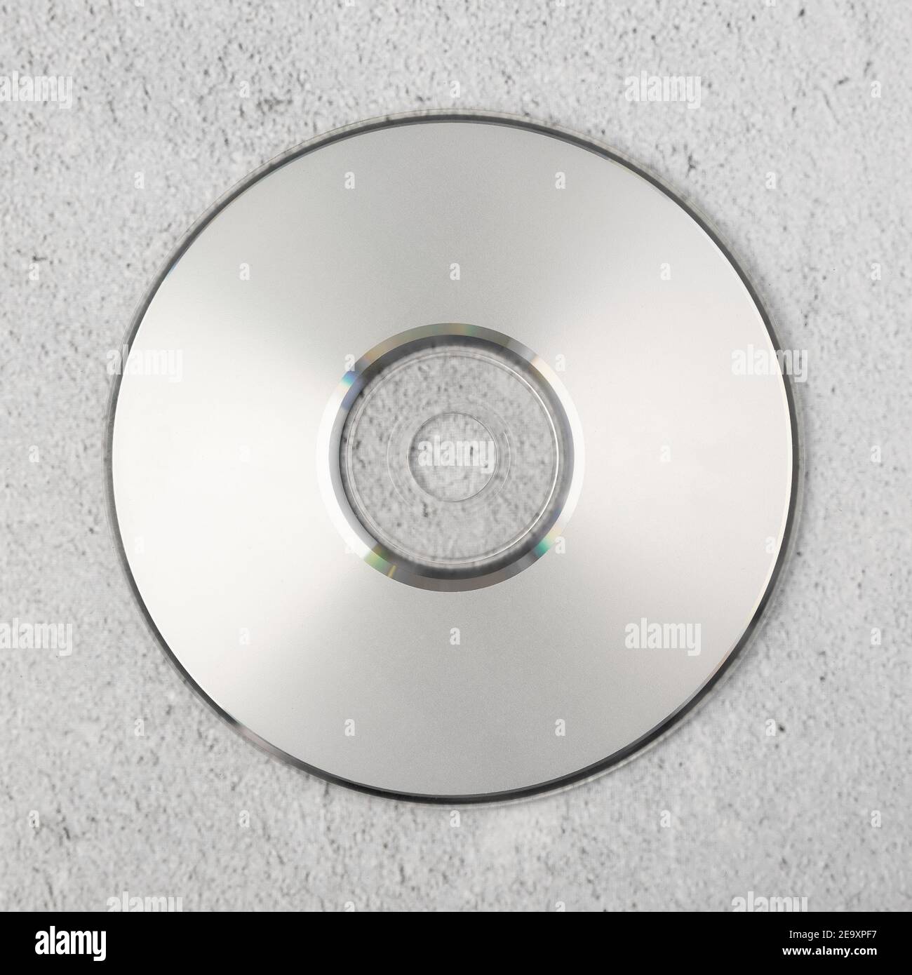 Modello cd bianco realistico su sfondo cemento bianco. Foto Stock