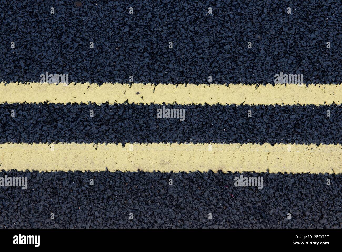 Due linee gialle dipinte di fresco su una strada asfaltata Foto Stock