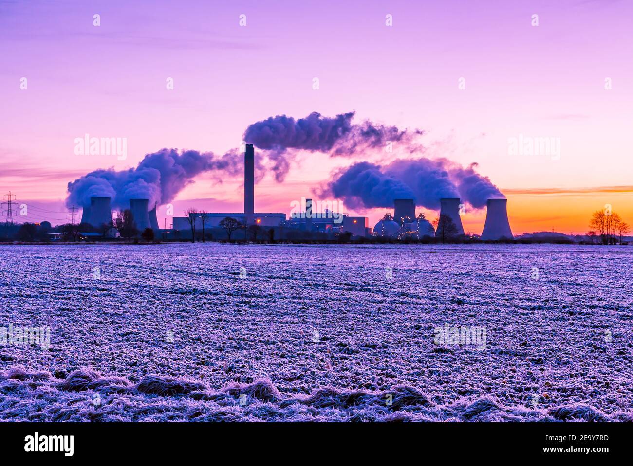 La mattina presto e un gelo duro sopra i campi agricoli in Drax, lo Yorkshire del nord. REGNO UNITO. Sole che sale verso est e percorsi di vapore acqueo da un Pow locale Foto Stock