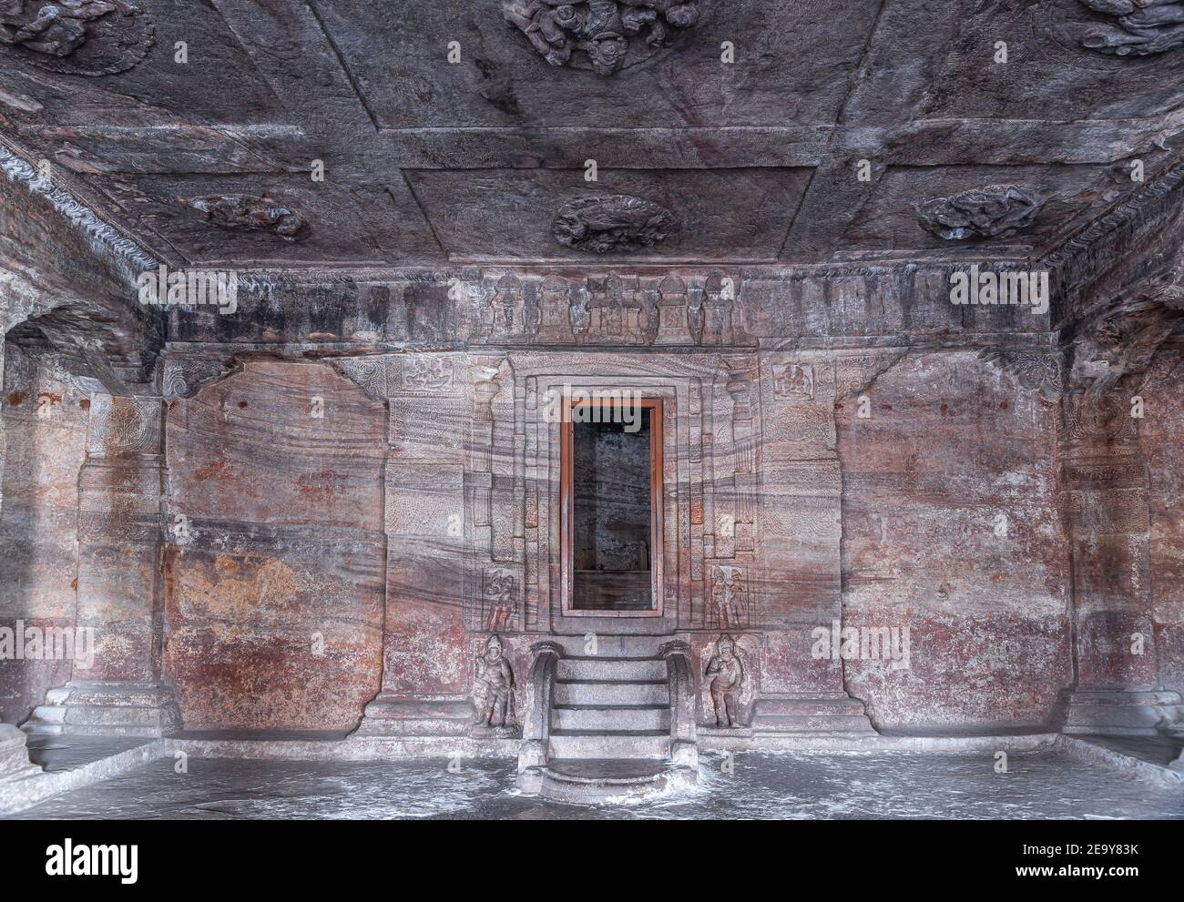 Badami, Karnataka, India - 7 novembre 2013: Templi in grotta sopra il lago Agasthya. La sala davanti al santuario vuoto mostra la porta e i gradini di colore multiplo Foto Stock