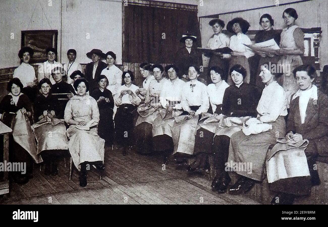 WWI - YWCA - Donne che fanno abiti caldi per soldati e cucire sacchi in una capanna britannica Y.W.C.A. - (la YWCA è indipendente dalla YMCA, ma alcune associazioni locali YMCA e YWCA si sono fuse). Anche se dovevano essere trovati in tutta la Gran Bretagna, molti membri di YMCA seguirono i soldati in prima linea o aree di conflitto in tutto il globo.da settembre 1917, YMCA era responsabile per la gestione di 150 munizioni lavoratori mense Foto Stock