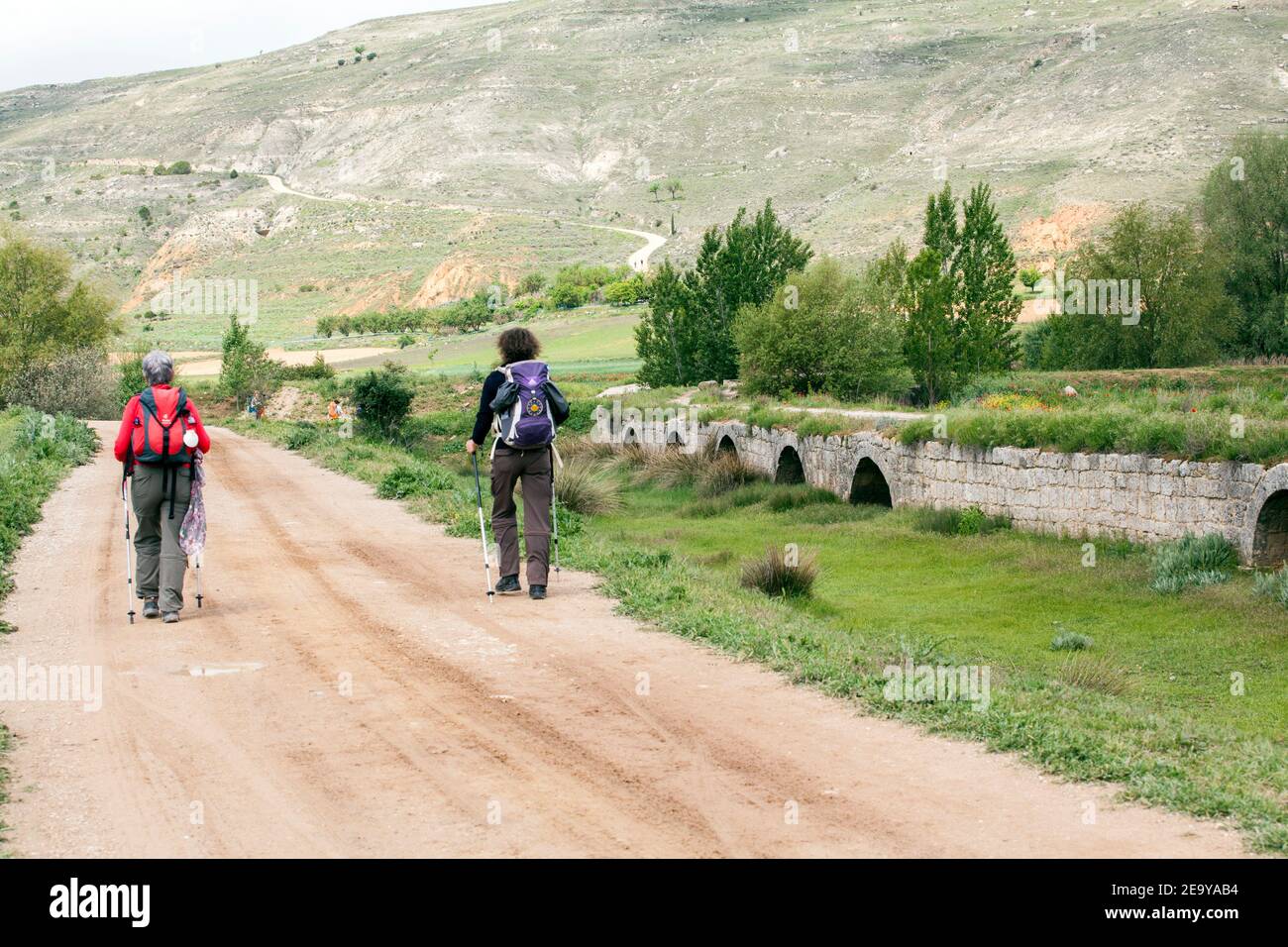 Pellegrini a piedi il Camino spagnolo de Santiago la via del pellegrinaggio di San Giacomo sulla strada romana e ponte di Castrojeriz Castilla y León Foto Stock