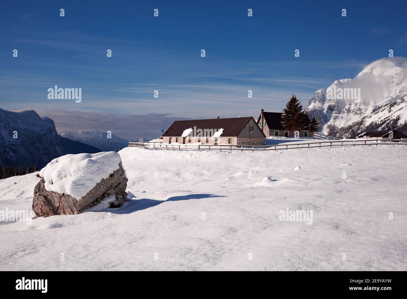 Fattoria di montagna in inverno con neve dintorni e alta montagna sfondo Foto Stock