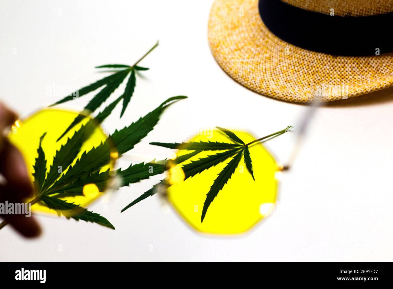 Uno sguardo alla vita attraverso i vetri gialli. Marijuana. L'effetto delle droghe sulla coscienza. Dipendente da droghe. Vita spensierata. Messa a fuoco selettiva Foto Stock