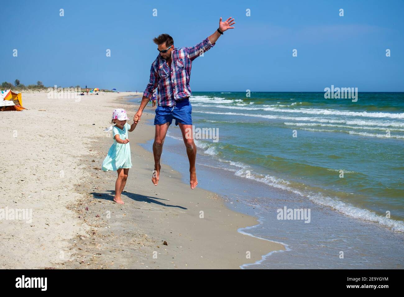La ragazza del bambino sta provando a mantenere il suo padre così non vola in cielo come una mongolfiera Foto Stock