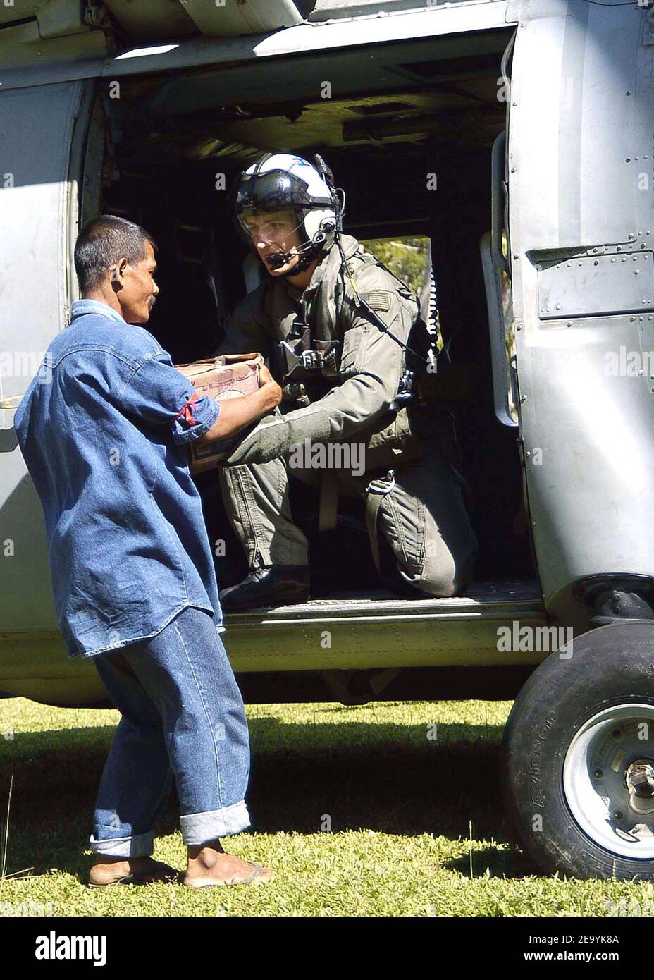 Aviation Warfare Systems Operator 2a Classe Dave Matthews di Freehold, N.J., consegna le forniture di soccorso da un elicottero SH-60F Seahawk ad un uomo indonesiano. Gli elicotteri assegnati alla Carrier Air Wing Two (CVW-2) e i marinai della USS Abraham Lincoln (CVN 72) stanno sostenendo l'operazione Unified Assistance, l'operazione umanitaria sulla scia dello tsunami che ha colpito il Sud Est asiatico. Foto di Seth C. Peterson/USN via ABACA. Foto Stock