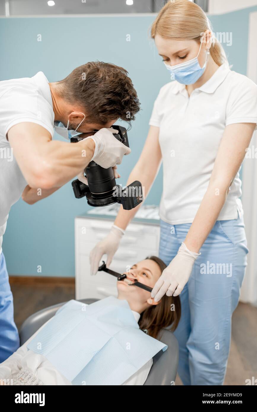Dentista che fotografa il risultato del suo lavoro Foto Stock