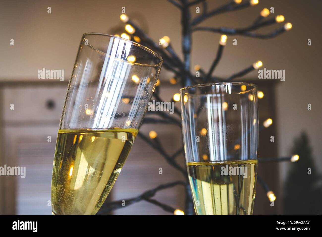 Due bicchieri di vino bianco e luci per una celebrazione Foto Stock