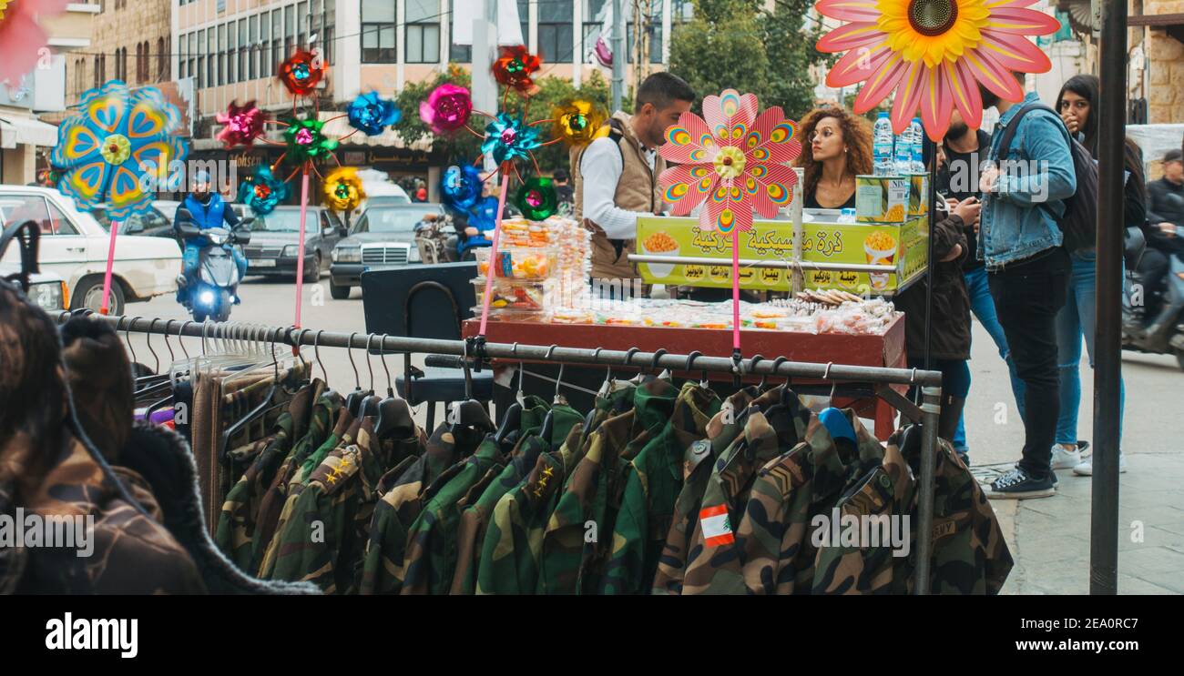 Novità camuffamento militare in vendita nella strada di Tripoli, Libano. Una giovane coppia compra spuntini da un venditore, dietro Foto Stock