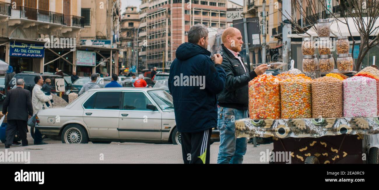 Un uomo vende caramelle e noci da un carrello sulla strada a Tripoli, Libano Foto Stock