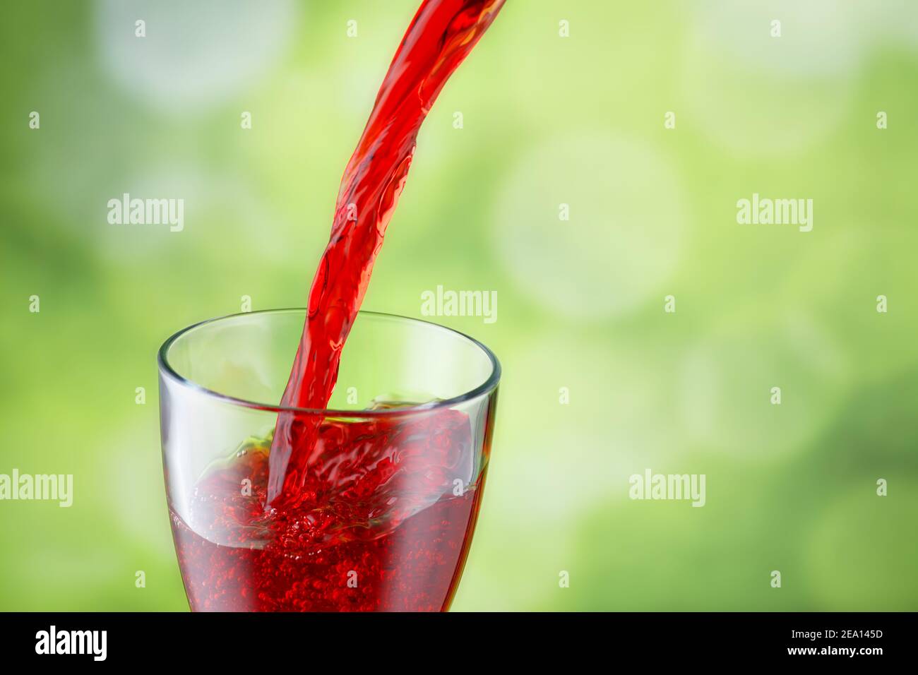 il succo viene versato in un bicchiere Foto Stock