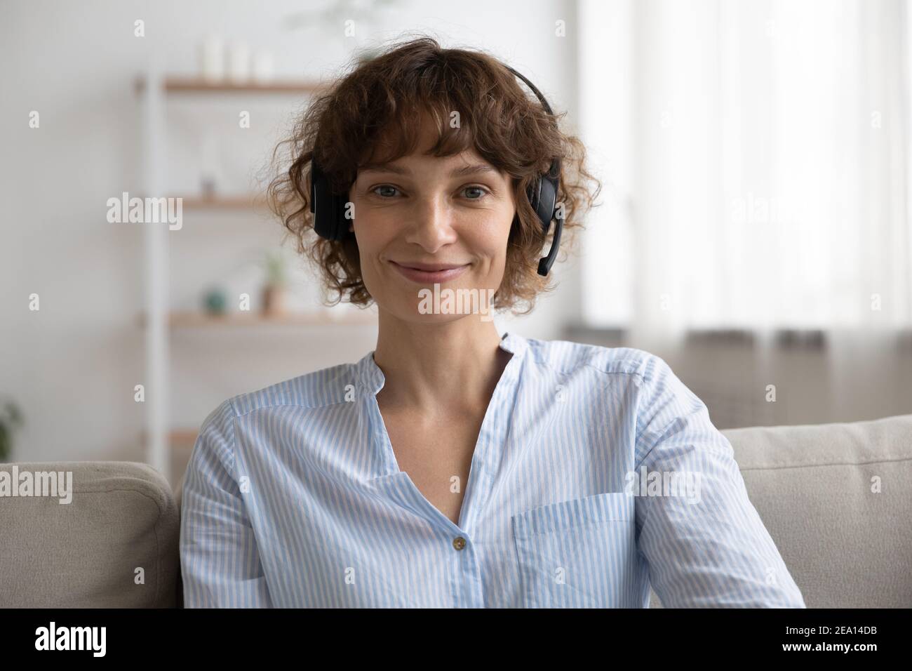Ritratto di donna in cuffia parla in videochiamata Foto Stock