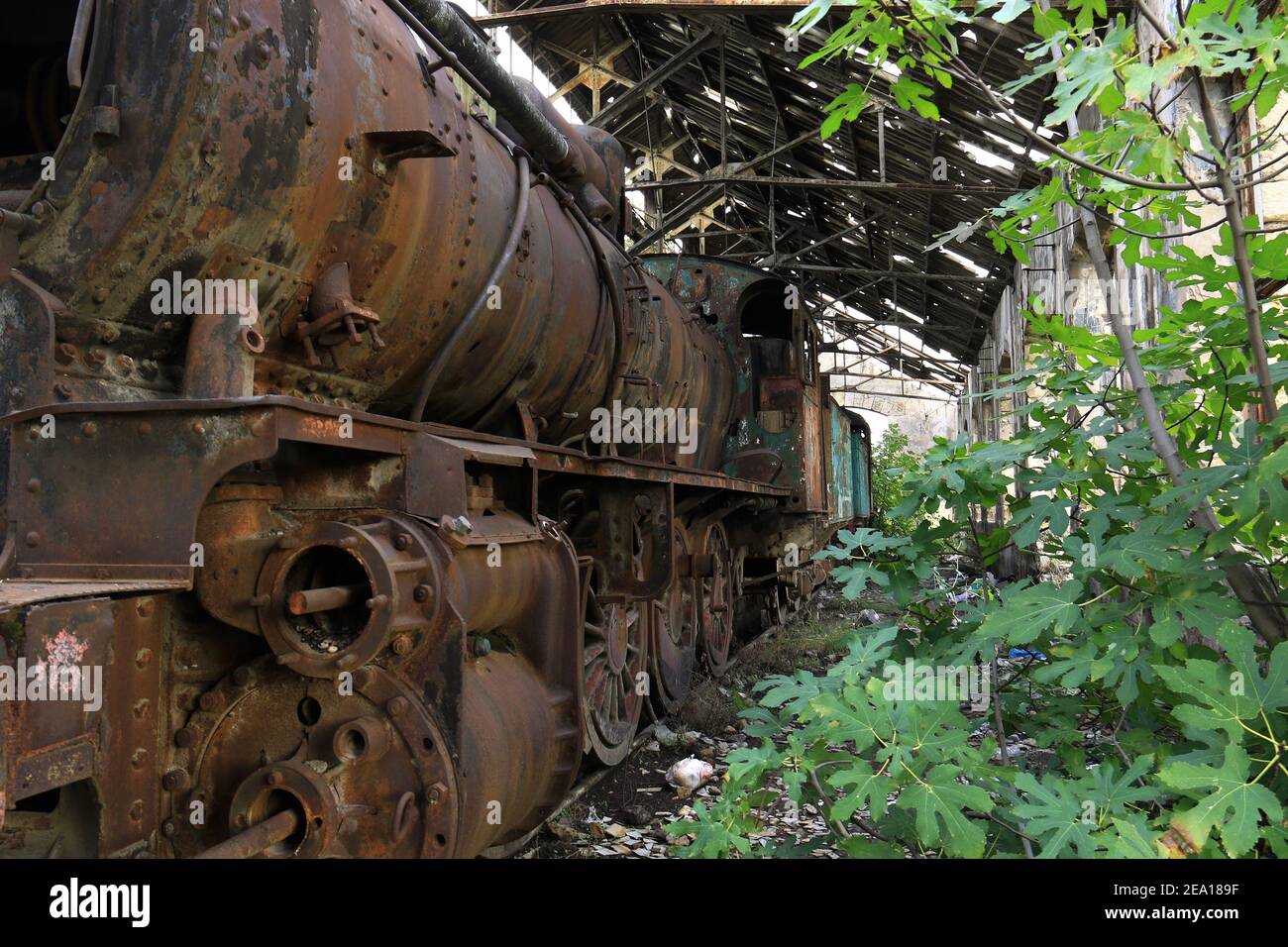 Un antico treno a vapore tutto arrugginito e rovinato. Foto Stock