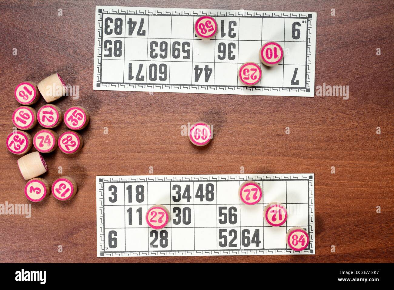 Gioco da tavolo lotto o bingo. Barili di lotto in legno con numeri e carte sulla scrivania marrone durante una partita a due giocatori. Gioco d'epoca, Russia. Foto Stock