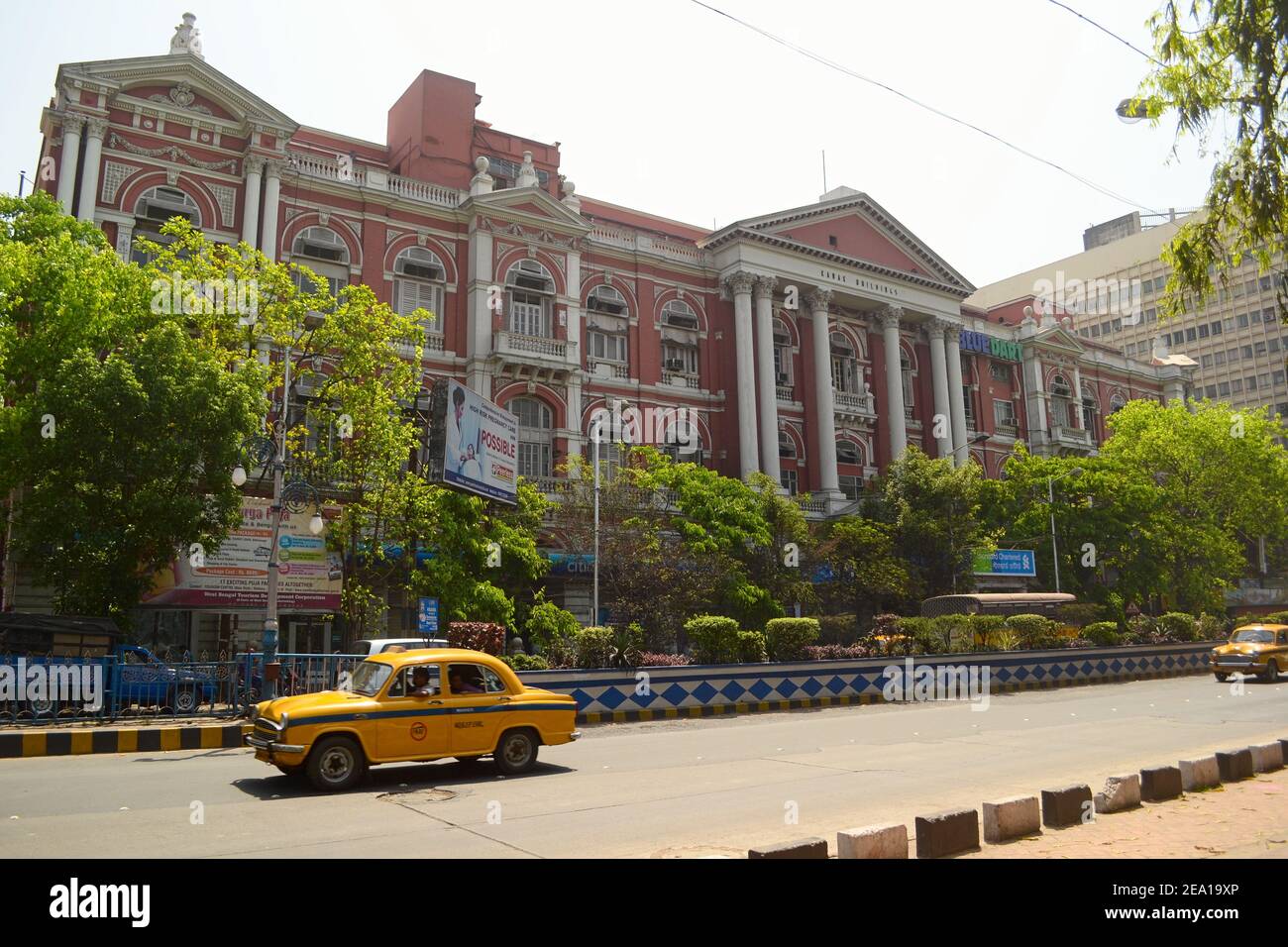 Kolkata, India - Marzo 2014: Antico edificio coloniale vicino Maidan a Calcutta. Tradizionale taxi retrò giallo sulla strada. Foto Stock