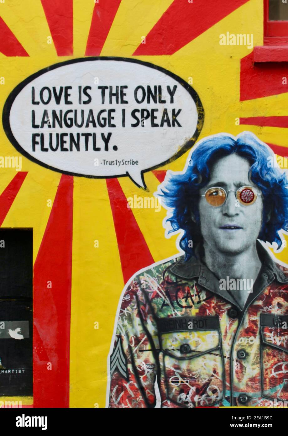 L'amore è l'unica lingua che parlo fluentemente. John Lennon muro arte da blocco Sabato a Brighton, Inghilterra. Tutto ciò di cui avete bisogno è l'amore. Messaggio di San Valentino Foto Stock