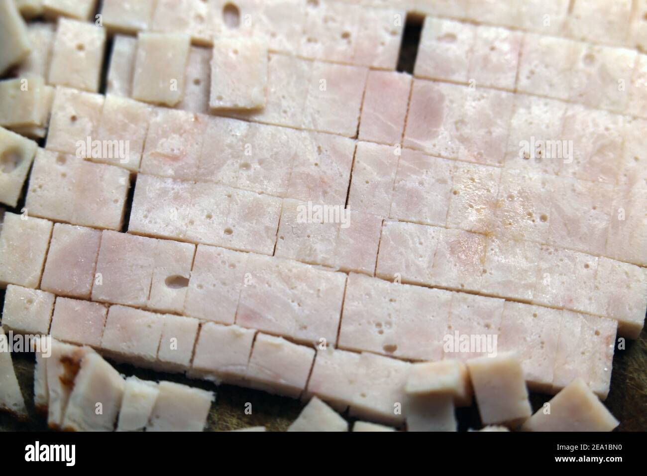 Preparazione degli alimenti per la cottura: Pezzi di tacchino tagliati a fette in un primo piano. Carne sana a basso contenuto di grassi da utilizzare per un'omelette. Cucina casalinga. Foto Stock