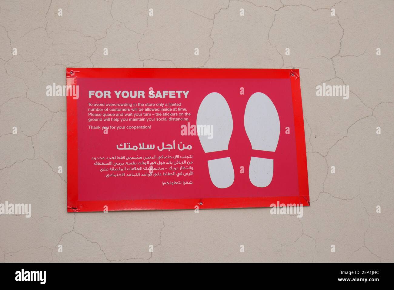 Cartello rosso in arabo e inglese al di fuori di un negozio che informa i clienti delle regole per proteggere contro COVID, Manama, Regno del Bahrain Foto Stock