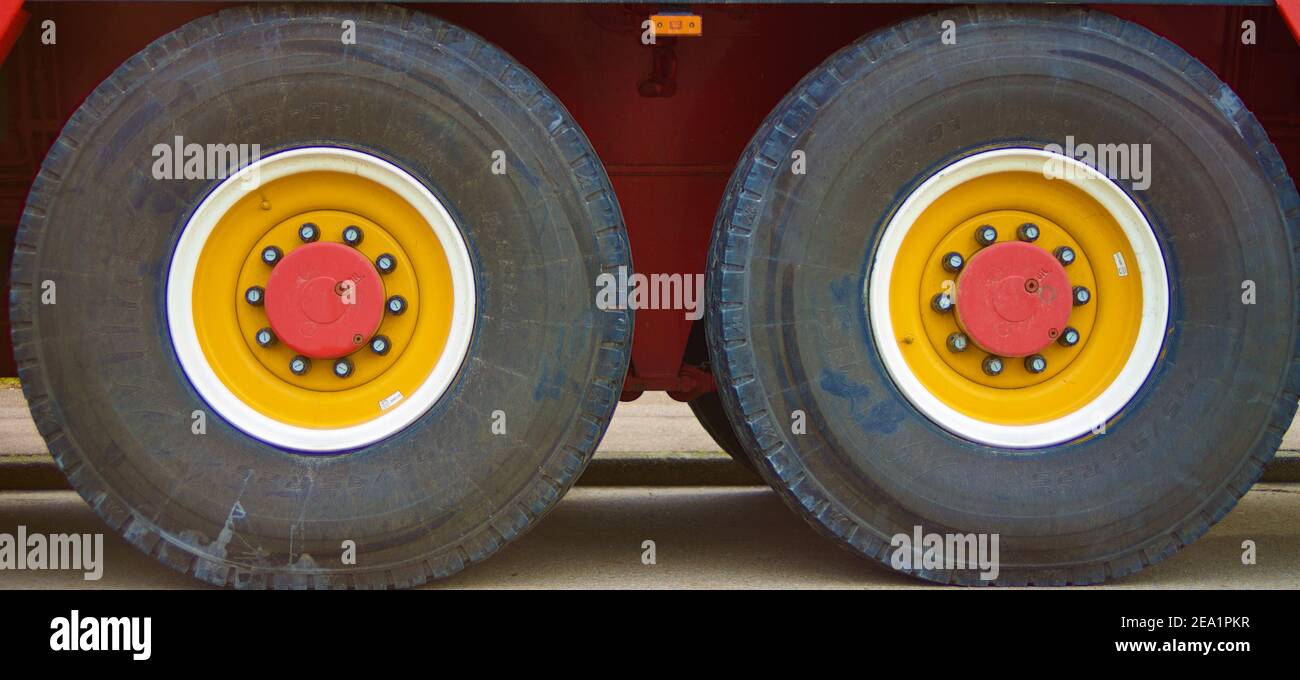 Ruota grande di un autocarro pesante con cerchioni gialli e. una cornice rossa Foto Stock