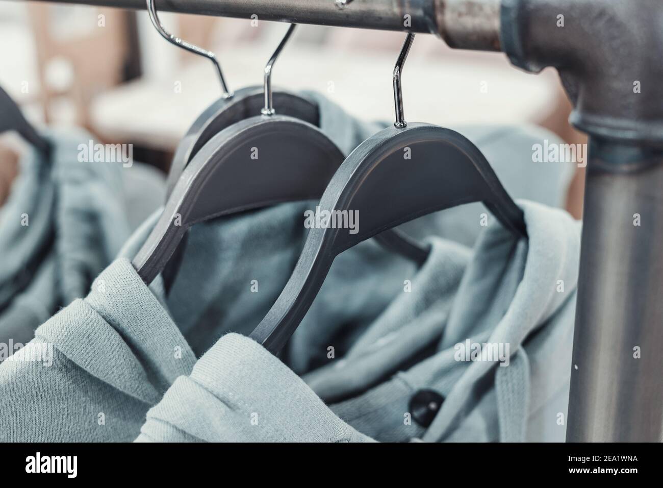 Felpe con cappuccio verdi sul rack. Concetto di abbigliamento e vendita di seconda mano Foto Stock