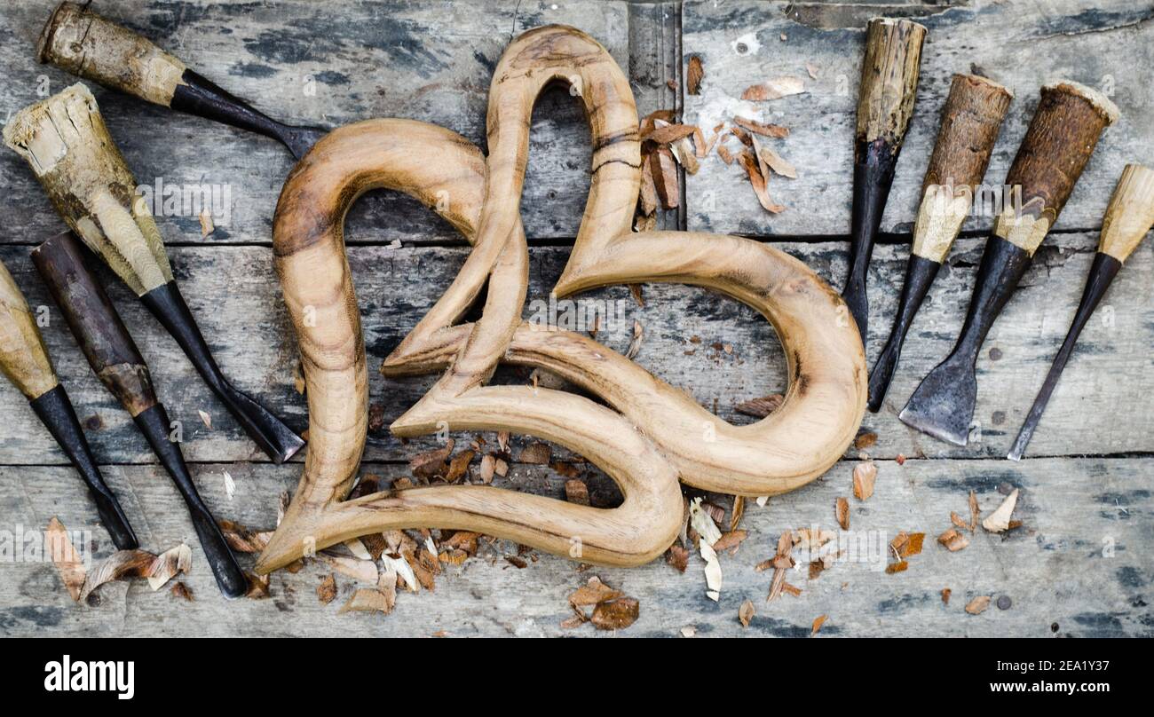 Il legno di cuore è posto su un pavimento di legno e una pasta di legno intagliata. Foto Stock