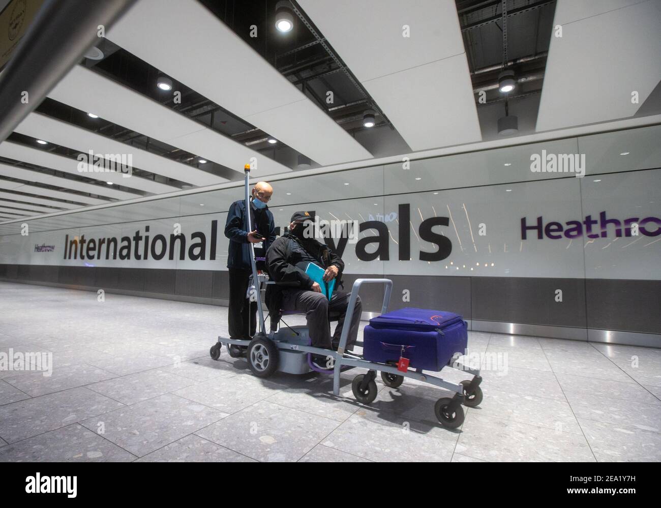 Passeggeri internazionali in arrivo al Terminal 5 di Heathrow. Le persone che arrivano da alcuni paesi dovranno mettere in quarantena per 10 giorni. Foto Stock