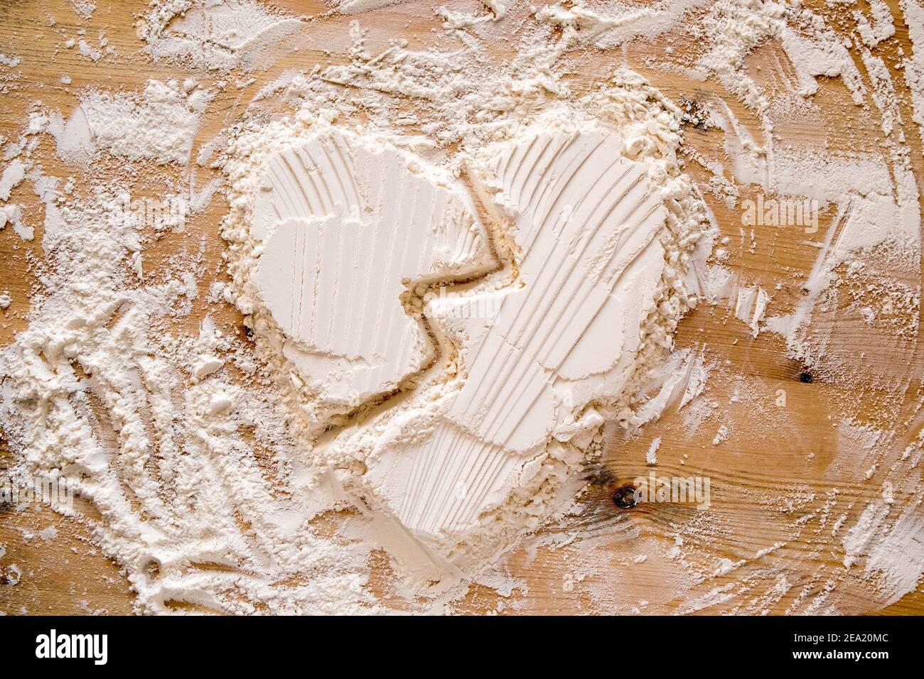 San Valentino. Il cuore rotto è un simbolo di amore fatto con la farina su una tessitura di legno. Spazio di copia. Concettuale. Foto Stock