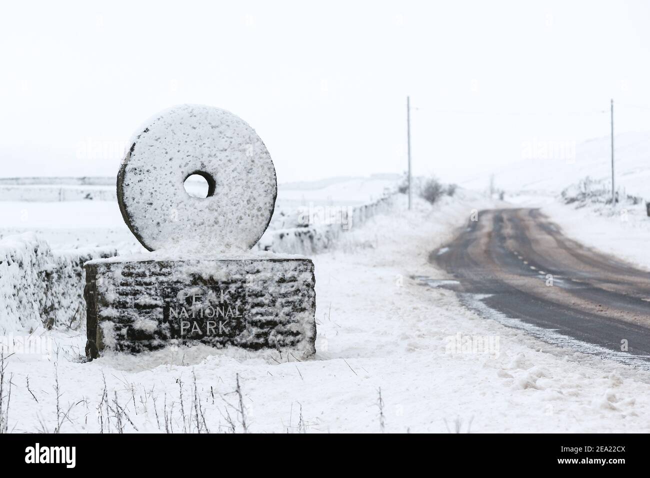 Vista di una macina innevata che segna l'ingresso al Peak District National Park sulla A635 / Isola di Skye Road. Molte aree della Gran Bretagna hanno sperimentato temperature gelide e neve durante la notte portata in aria fredda dalla Scandinavia e dalla Russia. Foto Stock