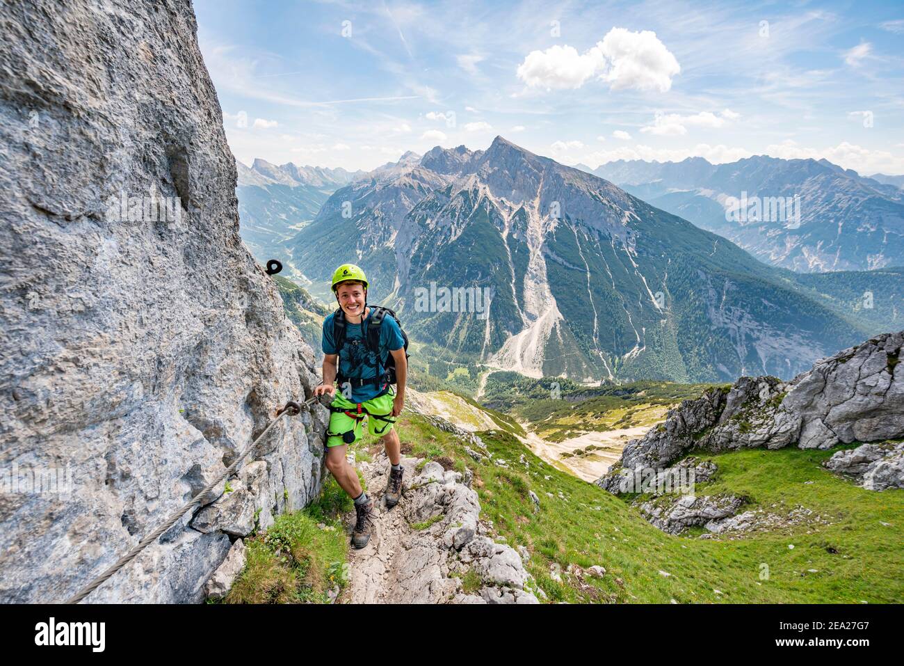 Alpinista su una sicura via ferrata, Mittenwalder Hoehenweg, vista del panorama montano, Karwendel Montagne, Mittenwald, Baviera, Germania Foto Stock